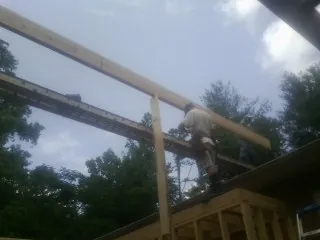 Carpenter setting a ridge beam over a new addition frame — Ice Dam Removal by Roofing Brothers in Brunsville