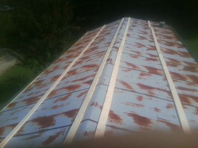 Rusted metal roof panels with new wood purlins before replacement — Storm Damage Roof Repair in Brunsville by Roofing Brothers