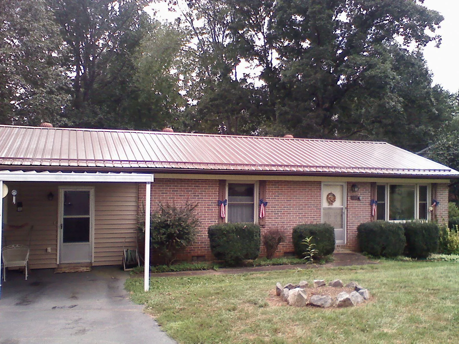 Bronze metal roof and carport on a brick ranch home — Roof Repair work by our crew in Brunsville